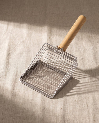Stainless Steel Litter Scoop with Wood Handle, styled in a home setting