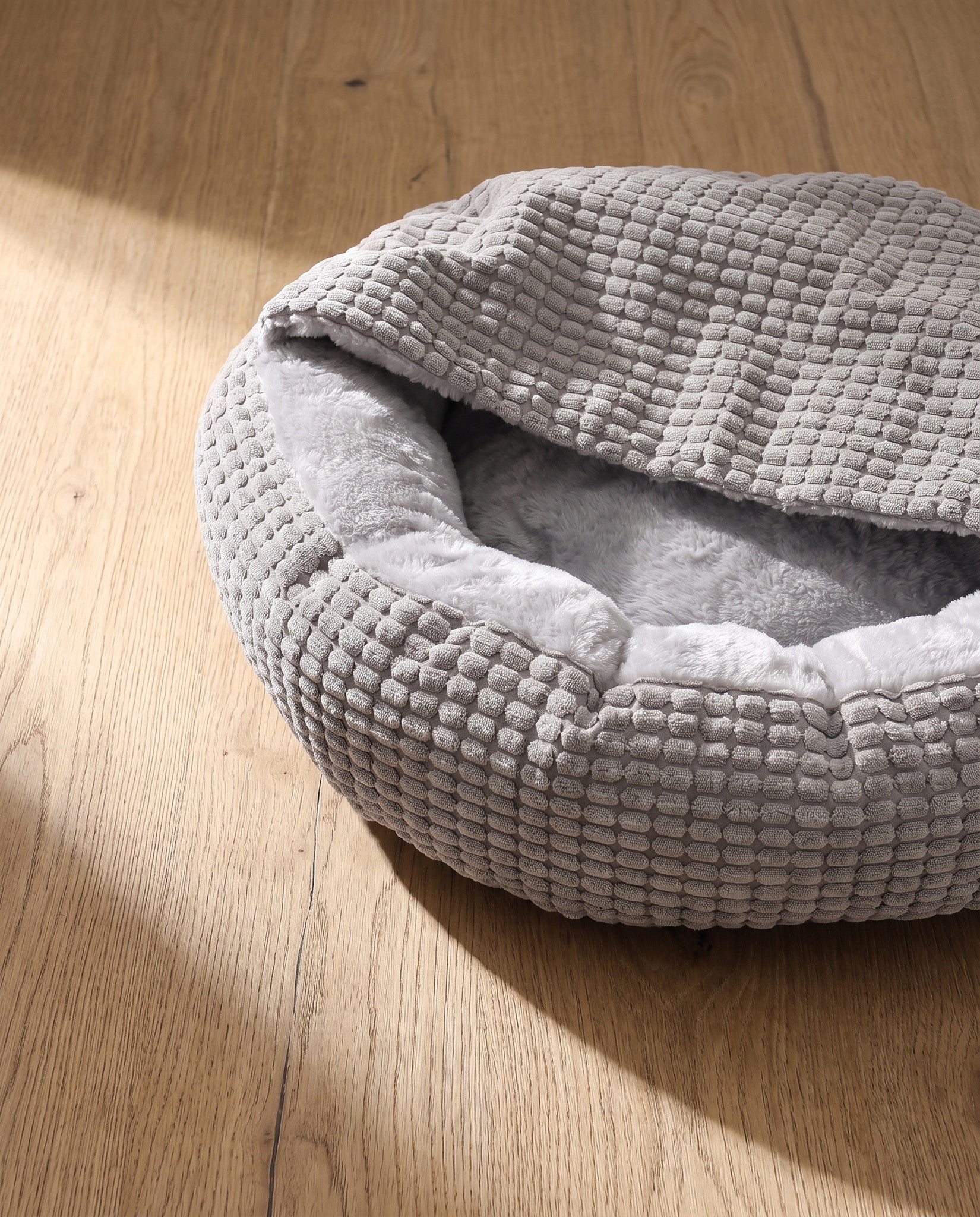 2-in-1 Hooded Cuddler Bed, styled in a home setting