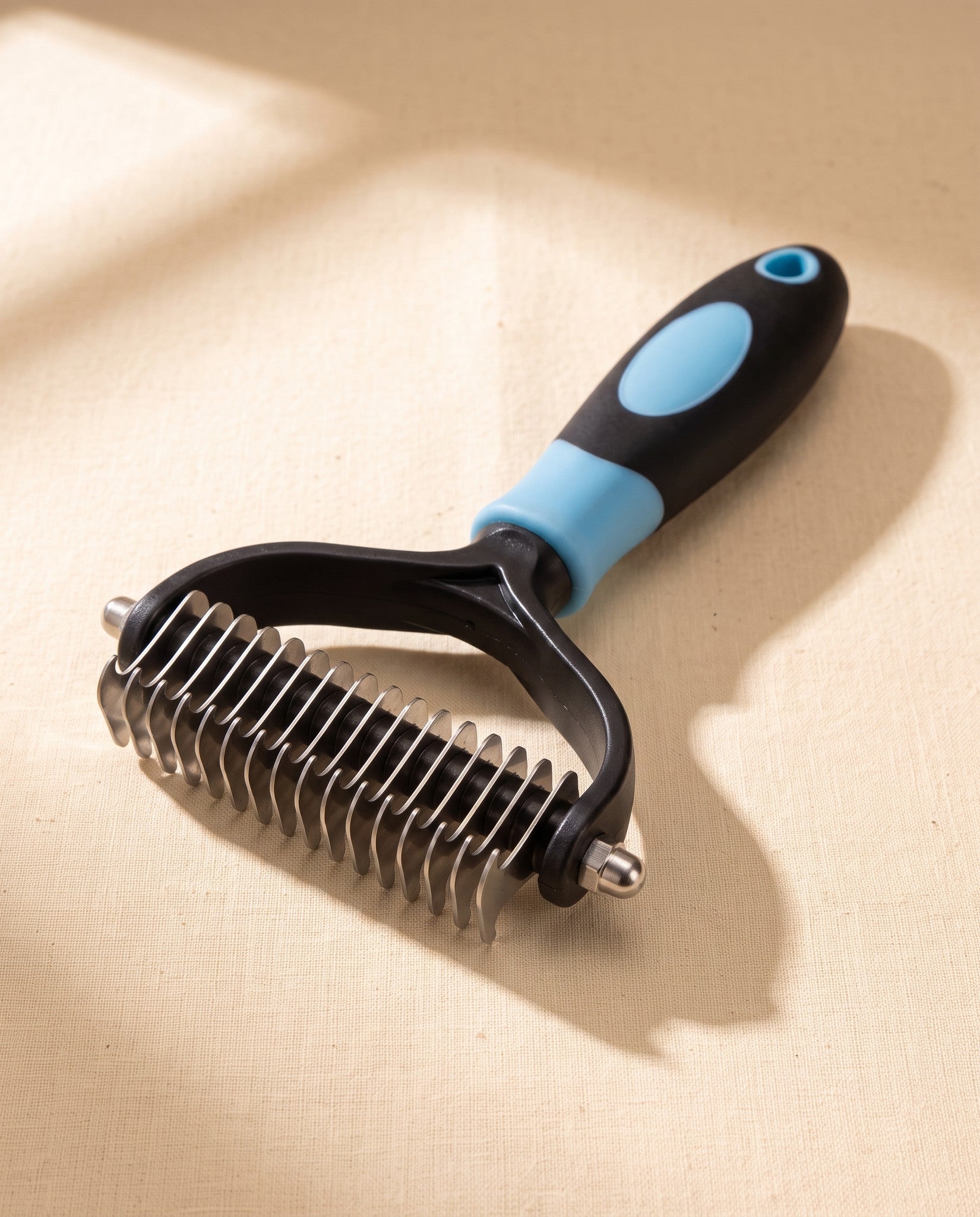 Two-Sided Dematting and Deshedding Rake, styled in a home setting